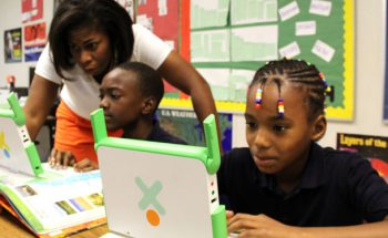 Bruns Academy third-grade teacher Cara Brown working with students and XO laptops provided through Project LIFT in Charlotte.